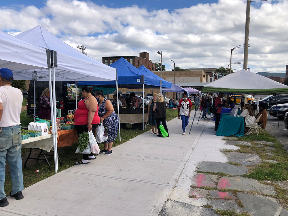 Residents stop by the tents to inquire about produce and other goods from venders.
